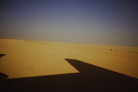 1987: Oman par Jacques Bernaux depuis le Fokker, vue sur la piste de l'aéroport de Marmul; les pistes sont balisées par d'anciens futs de carburants peints en blanc avec une bande blanche...